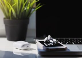 Close up smart phone, laptop computer and white wireless earphone. Minimalism workspace.