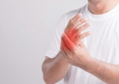 Palm pain concept : Close up man touching palm and feeling a pain. Studio shot isolated on grey background with copy space for text